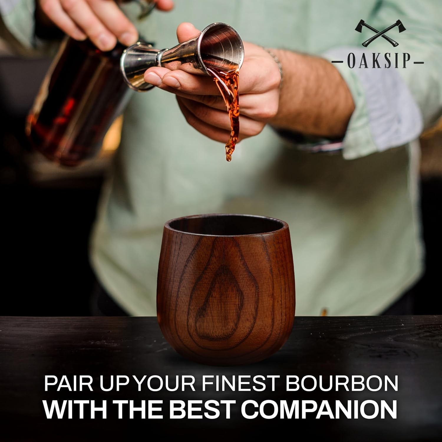 Whiskey being poured into a charred wooden bourbon glass cup